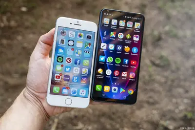 Hand holding an iPhone and an Android phone side by side for comparison